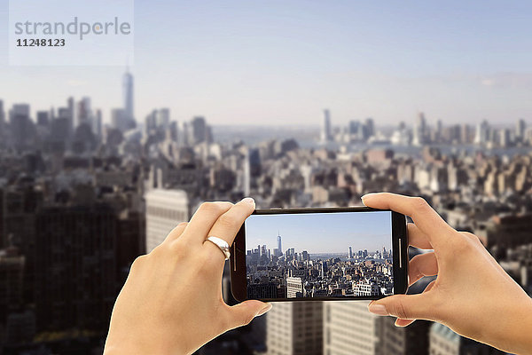 Die Hände fotografieren die Stadt