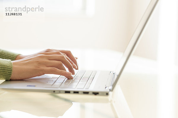 Hände beim Tippen auf der Laptop-Tastatur