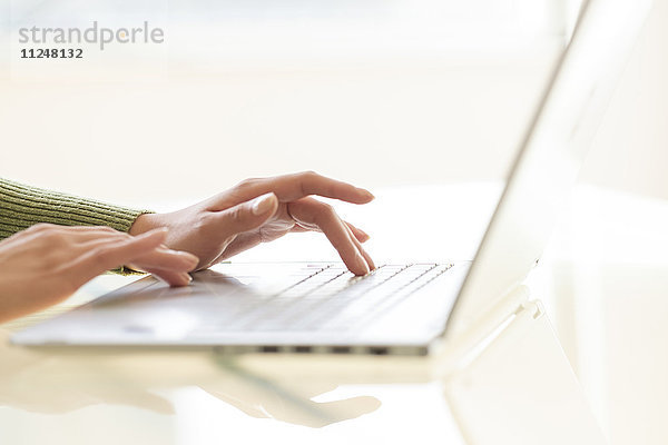 Hände beim Tippen auf der Laptop-Tastatur