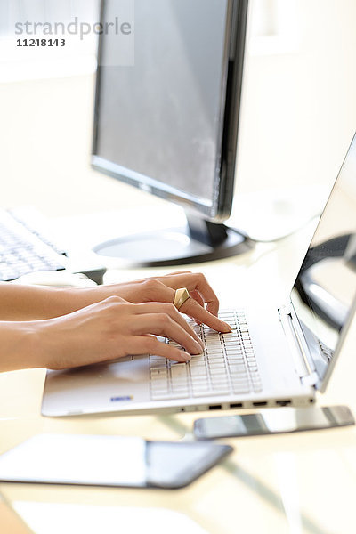 Hände beim Tippen auf der Laptop-Tastatur