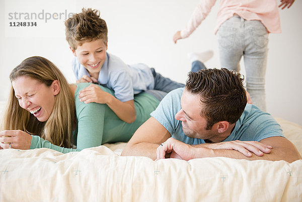 Familie mit zwei Kindern (6-7  8-9) im Schlafzimmer
