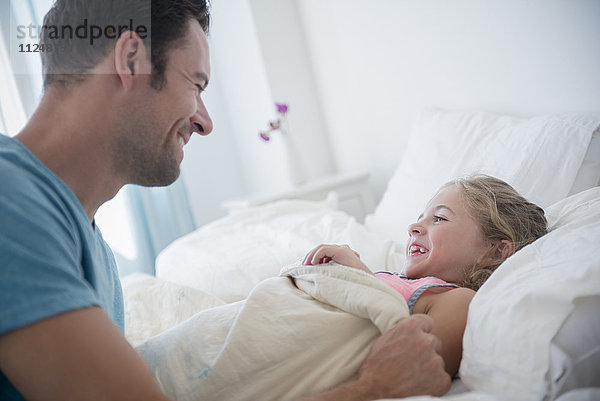 Vater bringt Tochter (6-7) ins Bett