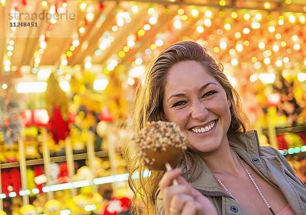 Frau mit karamellisiertem Apfel auf dem Jahrmarkt