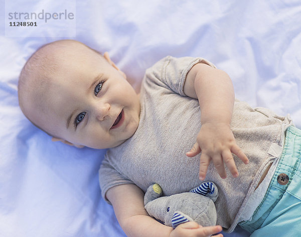Porträt eines kleinen Jungen (6-11 Monate) im Liegen