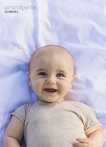 Porträt eines kleinen Jungen (6-11 Monate) im Liegen