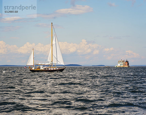 Segelboot im Meer und Rockland Harbor Breakwater Lighthouse in der Ferne