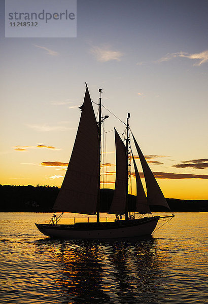 Silhouette eines Segelboots gegen den Himmel bei Sonnenuntergang