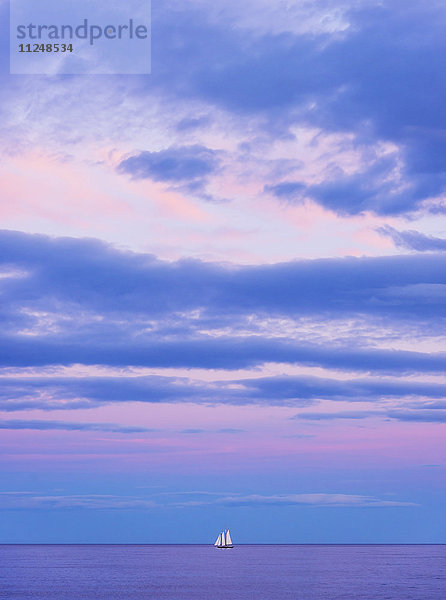 Pastellfarbene Meereslandschaft bei Sonnenuntergang mit Segelboot