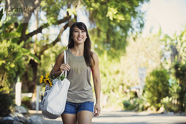 Junge Frau mit Einkaufstasche beim Gehen