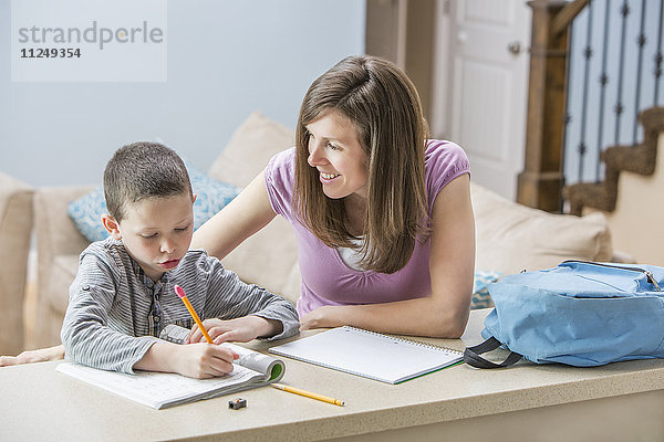 Mutter hilft Sohn (6-7) bei den Hausaufgaben