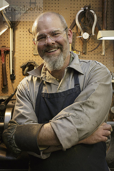 Porträt eines lächelnden Juweliers in einer Werkstatt