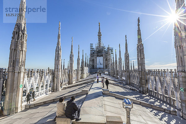 Touristen zwischen den weißen Marmortürmen auf der Spitze des Doms  Mailand  Lombardei  Italien  Europa
