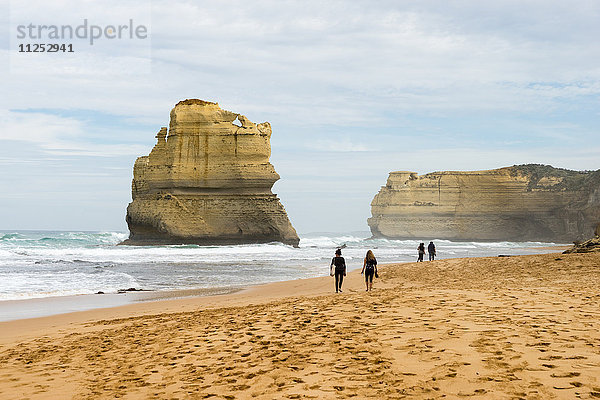 Spaziergang an einem Strand mit einer der geologischen Formationen der Zwölf Apostel im Hintergrund  Victoria  Australien  Pazifik