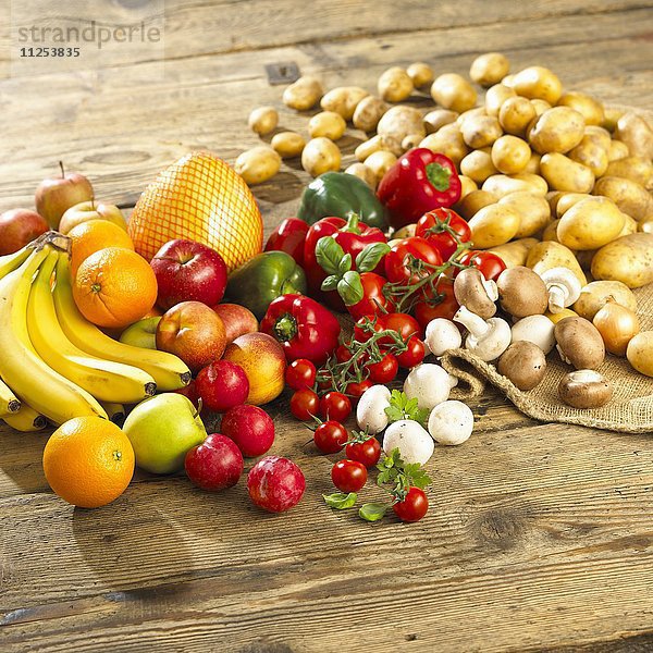 Gemüsestilleben mit Champignons und Obst auf Holztisch