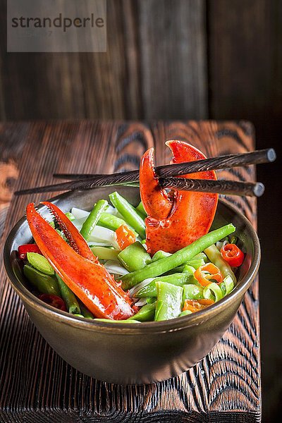 Nudeln mit Gemüse  Hummer und Essstäbchen (Asien)