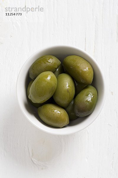 Oliven der Sorte Bella di Cerignola in weissem Schälchen
