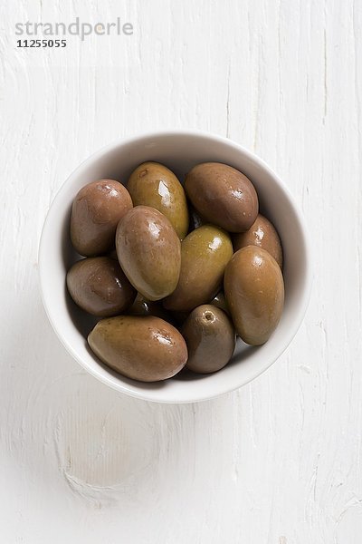Grüne Oliven in weissem Schälchen