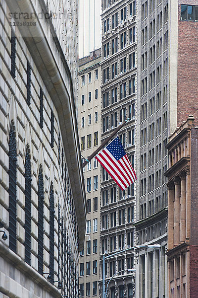 USA  New York State  New York City  Manhattan  Wall Street  amerikanische Flagge zwischen Wolkenkratzern
