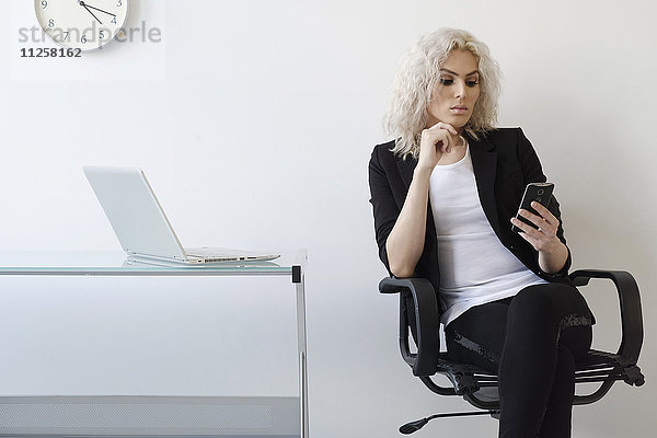 Junge Geschäftsfrau beim Telefonieren im Büro