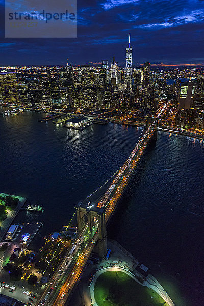 USA  New York  New York City  Manhattan  Luftaufnahme der beleuchteten Skyline mit Hafen und Brooklyn Bridge bei Nacht