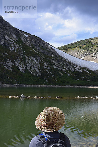 USA  Colorado  Idaho Springs  Wanderer sitzt am See unterhalb des St. Mary's Glacier