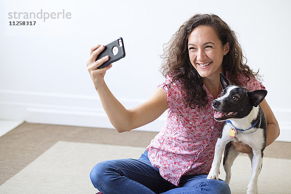 Junge Frau macht Selfie mit ihrem Hund