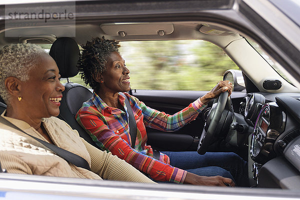 Zwei lächelnde Frauen im Auto