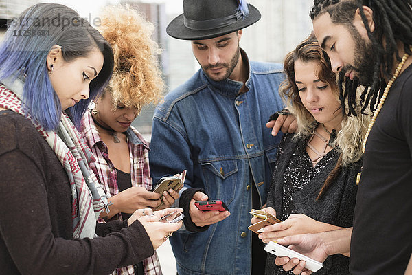 Junge Menschen nutzen Smartphones im Freien