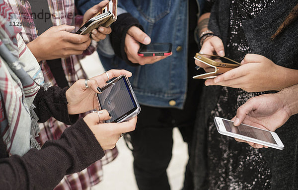 Junge Menschen nutzen Smartphones im Freien