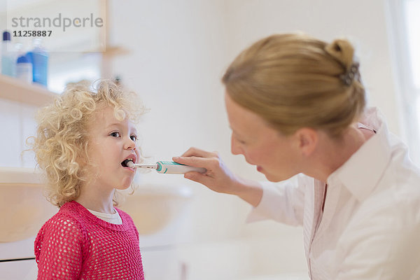 Mutter hilft Tochter (4-5) beim Zähneputzen