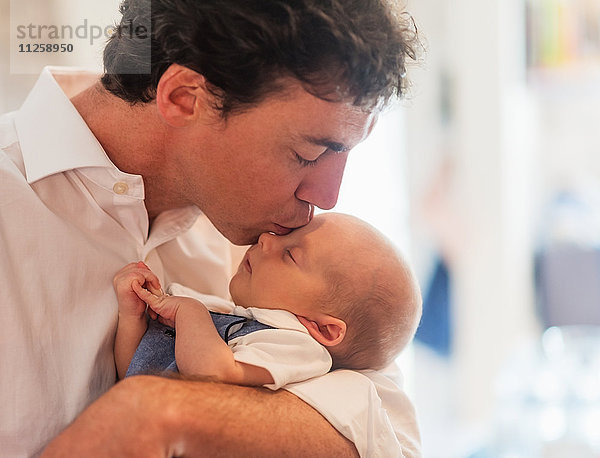 Vater küsst Babysohn (0-1 Monate)
