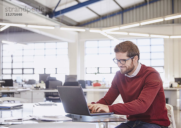 Geschäftsmann arbeitet am Laptop im Büro