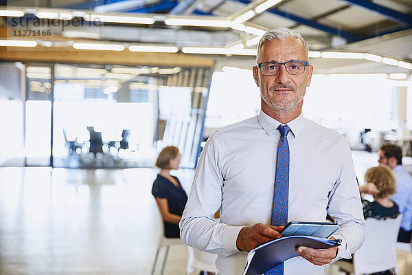 Porträt selbstbewusster Geschäftsmann mit digitalem Tablet im Büro