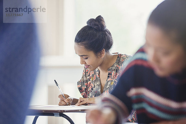 Studentinnen beim Test am Schreibtisch im Klassenzimmer