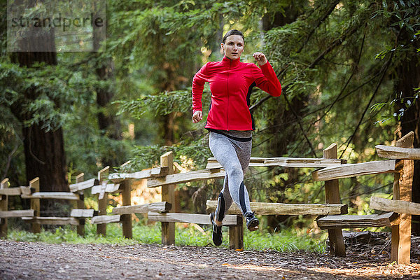 Frau läuft auf Waldweg