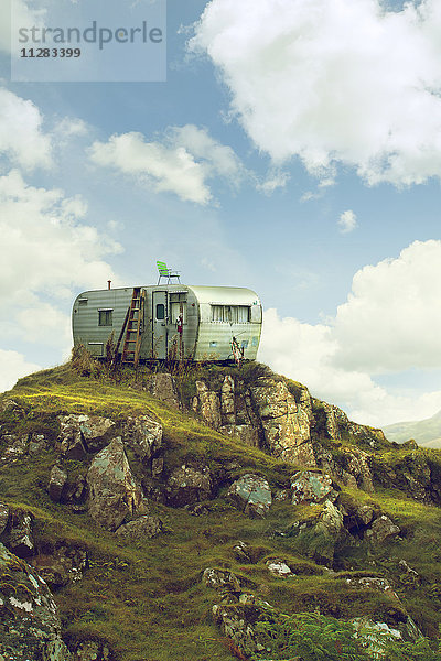 Wohnmobil auf einem Hügel in grüner Landschaft