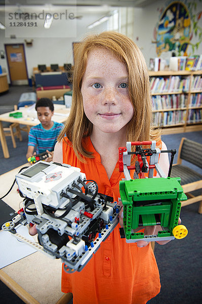 Mädchen posiert mit Plastikblöcken in der Bibliothek