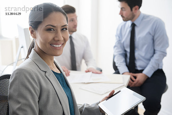 Lächelnde Geschäftsfrau mit digitalem Tablet im Büro