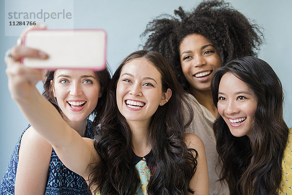 Lächelnde Frauen  die für ein Handy-Selfie posieren