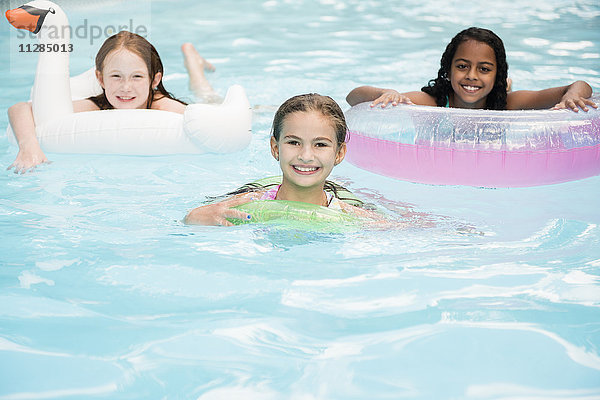 Porträt von lächelnden Mädchen  die im Schwimmbad schwimmen