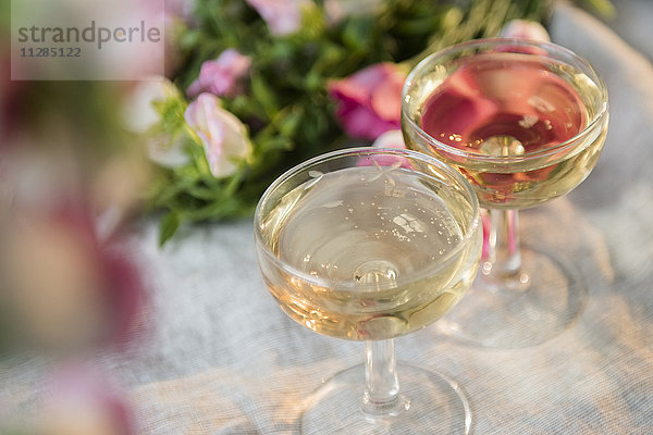 Gläser mit Champagner in der Nähe von Blumen