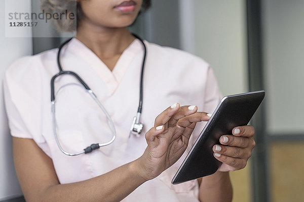 Gemischtrassige Krankenschwester mit digitaler Tafel