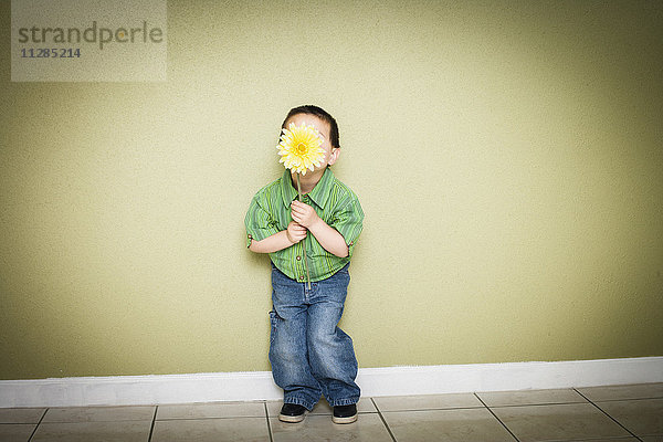 Mixed Race Junge hält Blume