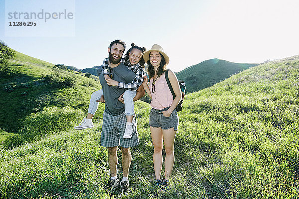 Porträt einer glücklichen Familie auf einem Hügel