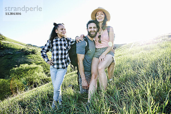 Porträt einer lächelnden Familie  die auf einem Hügel posiert