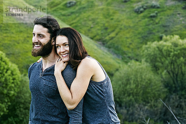 Lächelndes Paar auf einem Hügel stehend