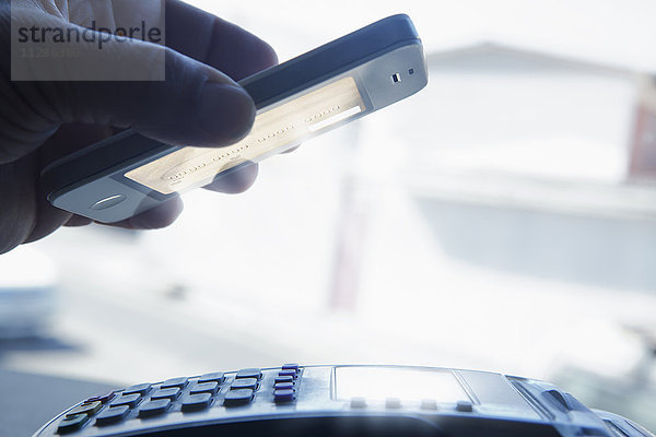 Hispanischer Mann zahlt mit Smartphone