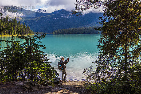 Kaukasischer Mann fotografiert Bergsee