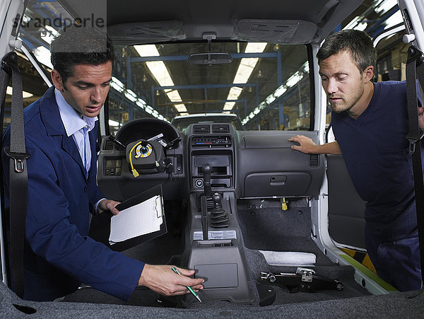 Zwei Männer bei der Inspektion eines Autos