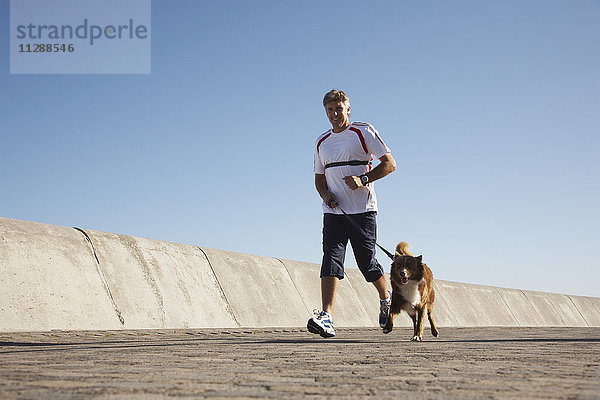 Mann joggt mit Hund